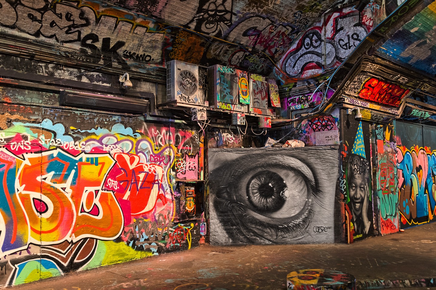 I'm always drawn to capturing street art wherever we travel. Leake Street Tunnel in Lambeth, London, also known as the "Banksy Tunnel" or "Graffiti Tunnel," runs about 300 meters under the platforms and tracks of Waterloo Station. It used to be a dark, abandoned stretch of road, now it's an ever-changing canvas for street artists from all over the world. This shot captures the layers of work covering the walls, political messages, abstract designs, and that huge eyeball staring back at you.
"London Eye" will be on display at @kickernickgallery's Fall Art Show, Artful Inspiration.
Join us at the show on opening night, October 22nd!
#londoneye #streetart #leakestreettunnel #fineartphotography #kickernick